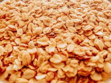 Yakın plan granola, kahvaltı tabağı, atıştırmalık. Fotoğrafta yulaf ezmesi ve bal var. Web siteleri için ürün ambalajının yanı sıra pankart ve makalelerde uygulama.