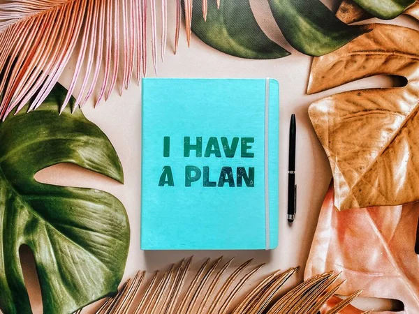 Notebook planner with the inscription I have a plan on a beautiful tropical summer background.
