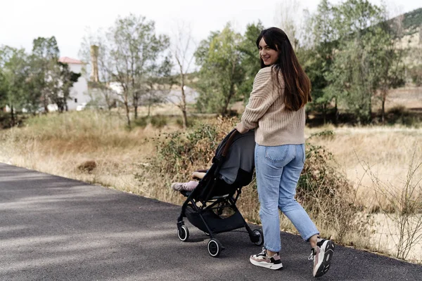 自然の中で赤ちゃんのカートで幸せな家族の散歩 — ストック写真