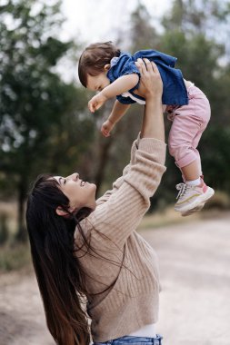 Mutlu anne, küçük kızıyla parkta eğleniyor.