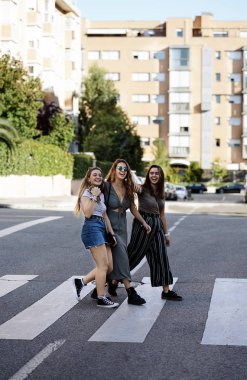 Gülümseyen ve bakınan üç arkadaş grubundan genç bir bayan.