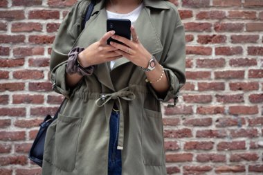 Akıllı telefon kullanan tanınmayan genç bir bayana yaklaş.