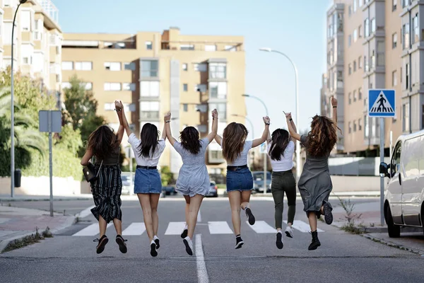 Grupo irreconocible de mujeres saltando y divirtiéndose en la calle — Foto de Stock