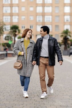 Şehirde birlikte yürüyen mutlu çift.