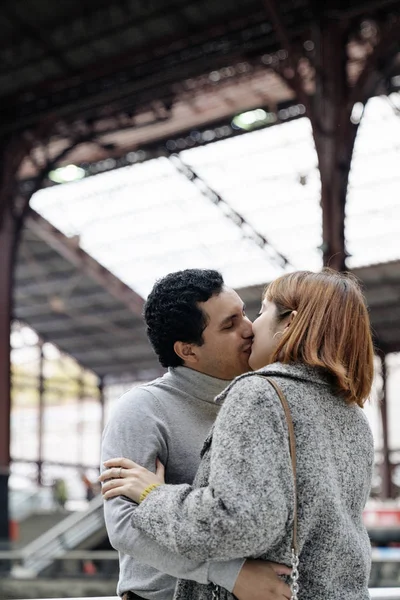 Couple kissing inside the train station — Stockfoto
