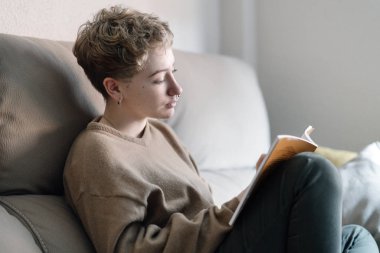 Genç ve güzel bir kadın evinde dinleniyor.