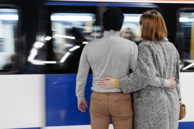 Tren istasyonunda öpüşen çift.