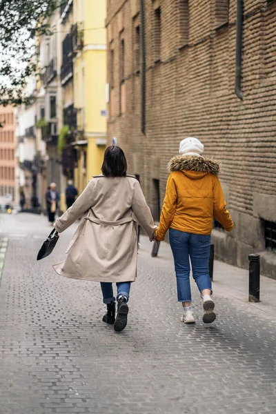 通りを歩いて2人の若い女の子のストック写真 手を握っている — ストック写真