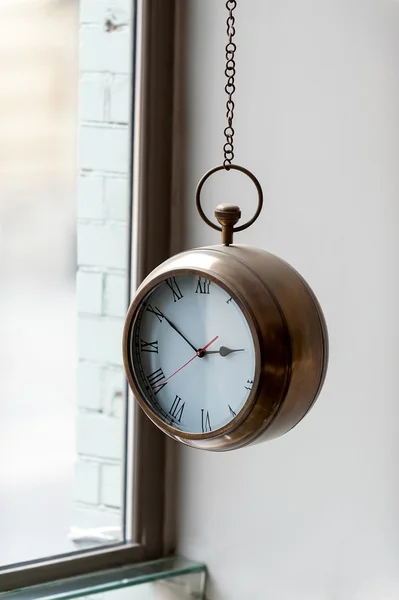 Original clock with metal case hanging on  chain — Stock Photo, Image