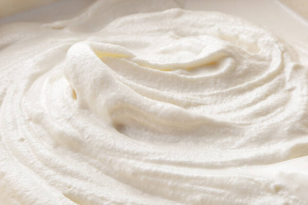 curls of whipped cream close-up textured background  