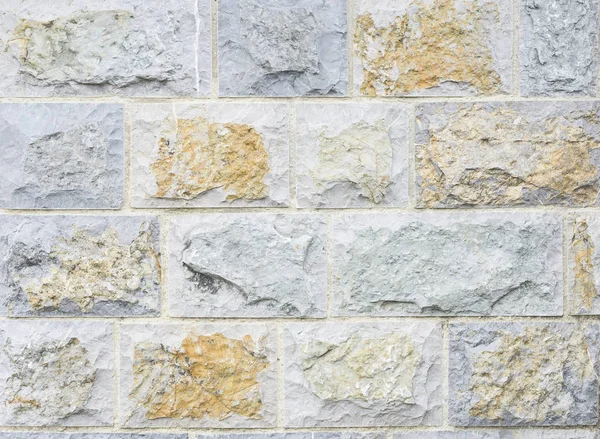 Stěna z obdélníkových vápencových kamenů v různých odstínech okru — Stock fotografie