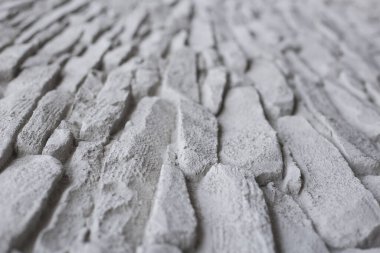 Arka plan olarak kullanılmak üzere taş duvardan oluşan beyaz bir duvar. seçici odak