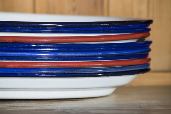Porselen banyolu metal tepsiler, kırmızı ve mavi kenarlı, antika tarzı, istiflenmiş. Gastronomi işleri için.