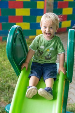 Slayt üzerinde gülümseyen sevimli küçük çocuk