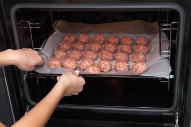 Kadın elleri fırında köfte yapıyor. İsveç çiğ köftesi. Ev yapımı kızarmış biftek köftesi..