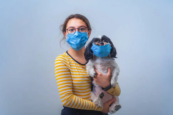 Gadis Remaja Bertopeng Medis Memegang Anjing Dengan Topeng Pelindung Latar — Stok Foto
