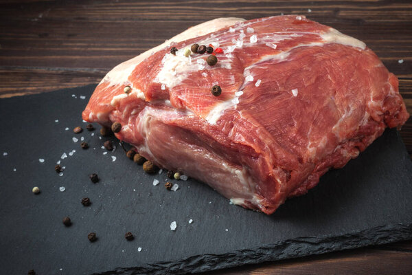 Raw pork chop steak on a black board. Pork antricot. meat