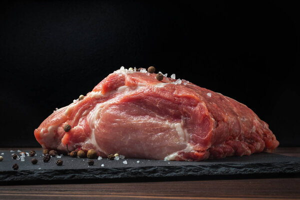 Raw pork chop steak on a black board. Pork antricot. meat
