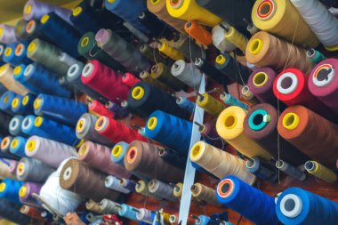 Dikiş atölyesindeki bobinlere renkli iplik. Giyim endüstrisi konsepti