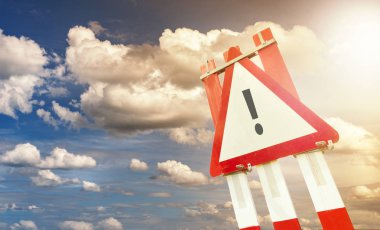 İnşaat alanında dramatik gökyüzü günbatımı ünlem işareti karşı uyarı işareti yol işareti