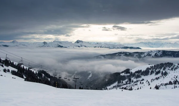 Cloudy winter landscape with sea of clouds and peaks above the clouds