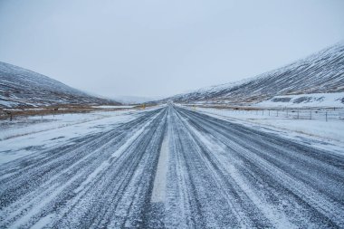 Kar fırtınasında kış yolu. Yolun karşısına kar üflüyordu. İzlanda 'da kış mevsiminde zor sürüş koşulları. 