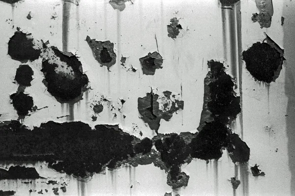 Paslı ve soyulmuş metal bir duvarın siyah beyaz analog fotoğrafını çek...