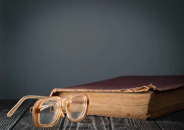 Книга, очки на столе — стоковое фото