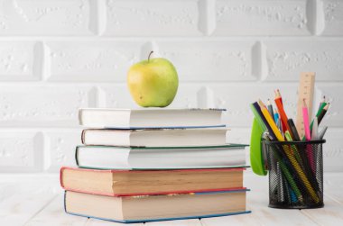 Okul malzemeleri masanın üstünde.