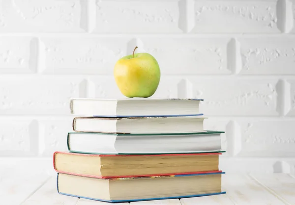 Livres sur table et une pomme — Photo