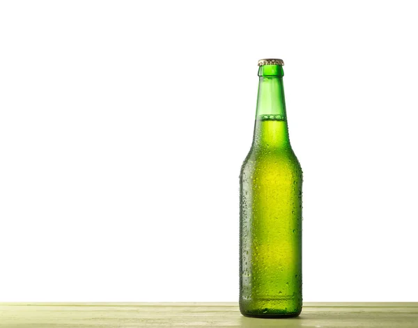 A bottle of beer on a green table — Stock Photo, Image