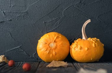 ahşap masa üzerinde iki turuncu kabak