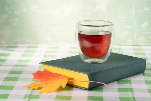 Livre, verre de thé et feuille d'automne — Photo