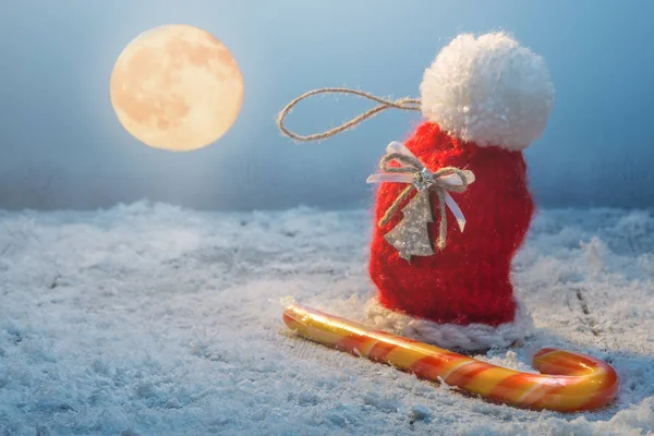 Игрушка и конфетка на снегу — стоковое фото