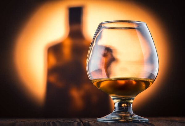 A glass of cognac on wooden table