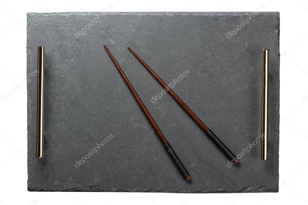 Chopsticks on  black slate tray isolated on white