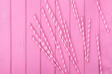 Drinking straws on the red table, close up clipart