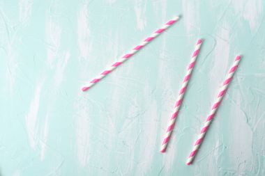 Drinking straws on the blue table background clipart