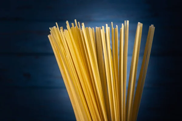 Espaguetis Italianos Secos Cocina Sobre Fondo Azul —  Fotos de Stock