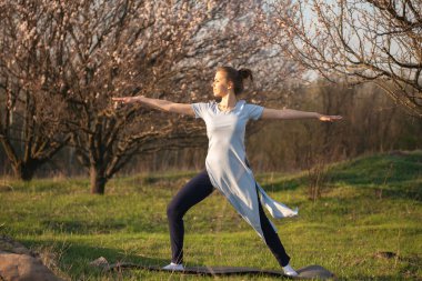 Kadın pratik yoga bir doğal zemin üzerine mavi