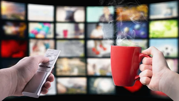 Oglądanie nowoczesnej telewizji z filiżanką gorącej kawy — Zdjęcie stockowe