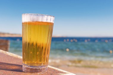 Deniz kenarında bir bardak bira.