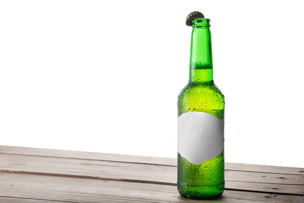 孤立した背もたれを持つテーブルの上にオープンキャップを持つビールのボトル — ストック写真