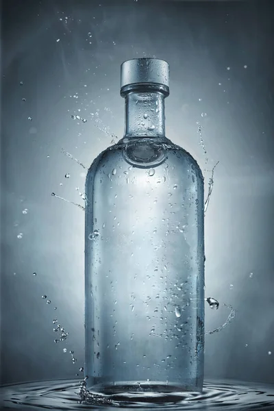 一瓶伏特加酒 蓝色底色上有水花 — 图库照片