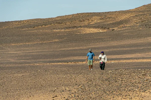 Fas 'ta çölde yürüyen iki erkek turist. — Stok fotoğraf