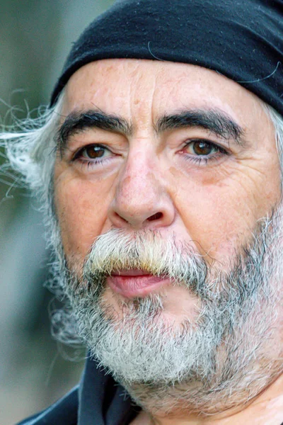 Beyaz saçlı, beyaz sakallı beyaz bir adamın portresi.