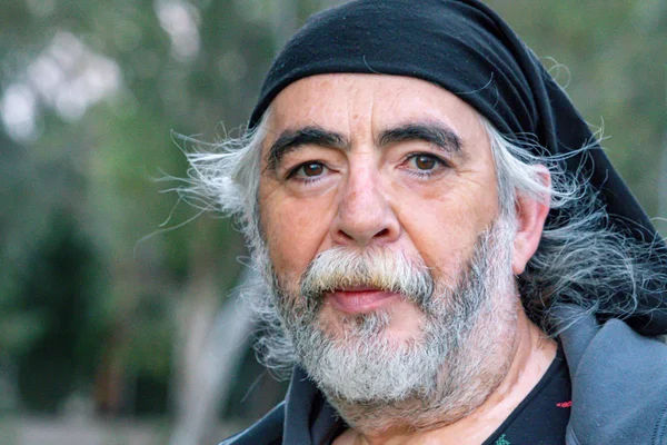 Beyaz saçlı, beyaz sakallı beyaz bir adamın portresi.