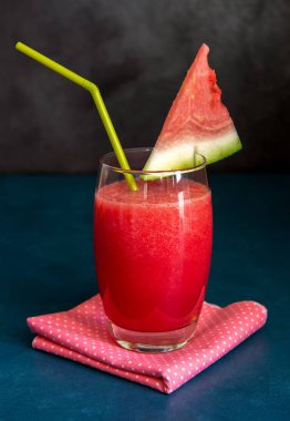 Siyah arka planda kamışlı karpuz smoothie.