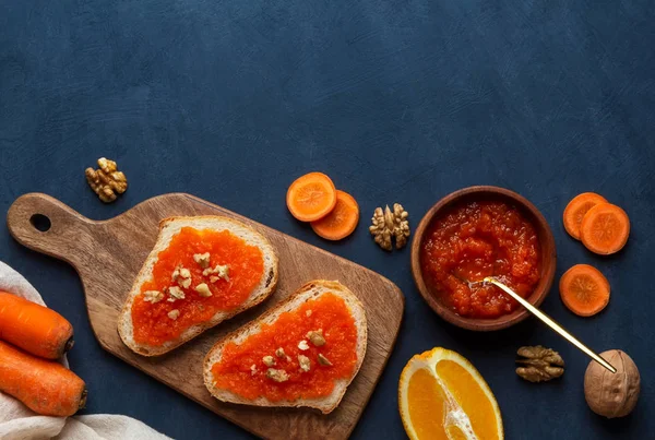 Sandwiches mit Karottenmarmelade auf einem Schneidebrett vor blauem Hintergrund — Stockfoto