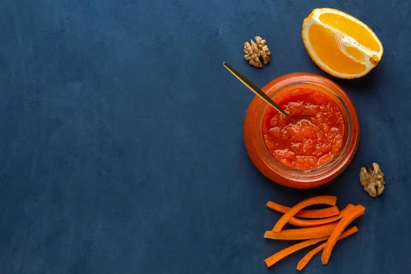 A jar of carrot jam on a dark background with a copy space — Stock Photo, Image